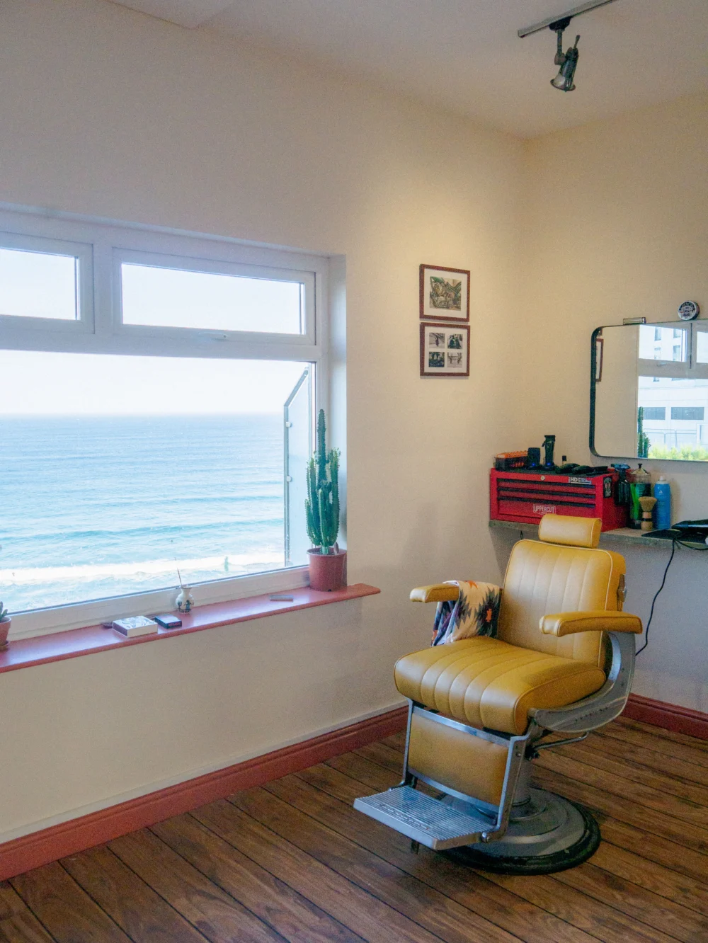 A barber chair beside a window overlooking the sea at 10 Over Surf Shop in Newquay.
